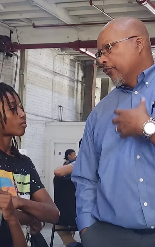 AAI founder Isaac Nash-Bey speaking with a student in the lab